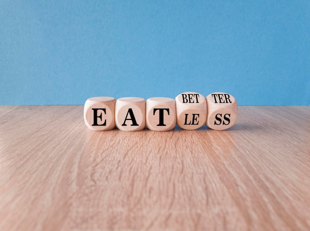 Foto eet beter of minder symbool gedraaide blokjes en veranderde woorden eet minder om beter te eten