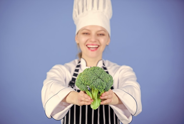 Eet gezond Meisje draag hoed en schort houd groente Gezond rantsoen Vrouw professionele chef-kok houdt rauwe broccoli groente Gratis gezonde vegetarische en veganistische recepten Gezond rauw voedsel Dieetconcept