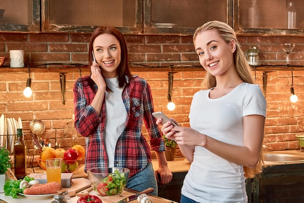 Eet goed, voel je goed, zie er goed uit jonge vrouwelijke vrienden die samen een vegetarische maaltijd bereiden in modern