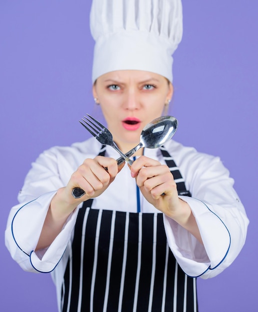 Eetlust en smaak. Traditioneel culinair. Professionele kok van culinaire school. Culinaire kunstacademie. Culinair schoolconcept. Vrouw professionele chef-kok houdt gebruiksvoorwerp lepel en vork. Tijd om te eten.