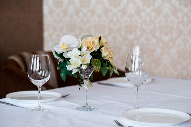 Eettafel gedecoreerd met bloemen.