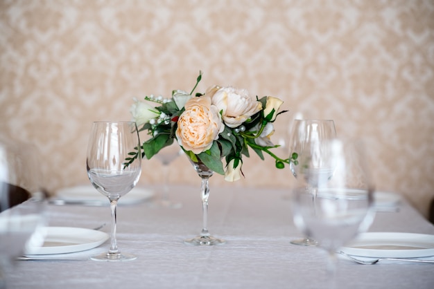 Eettafel gedecoreerd met bloemen.