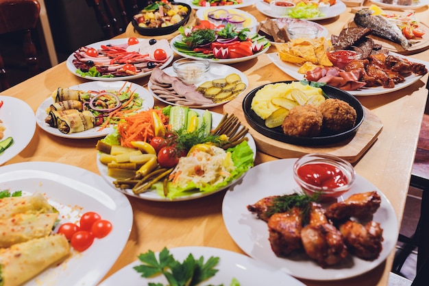 Eettafel met verschillende snacks en salades. Zalm, olijven, wijn, groenten, gegrilde vis toast.