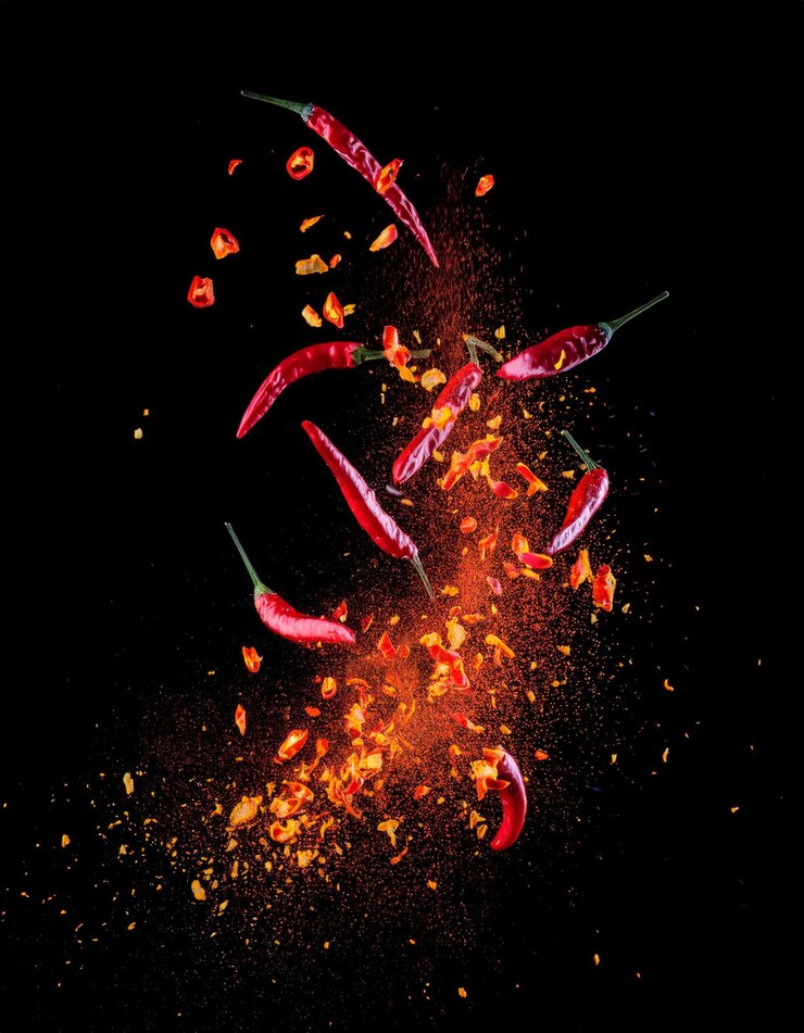 Photo effect photo with random exploding chili pieces scattered with a little bit of fire