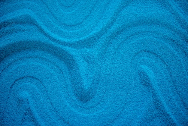 Foto effen blauw zand met verschillende patronen blauwe turquoise kleur tekening in het zand