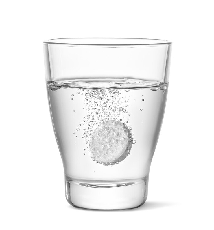 फोटो an effervescent tablet is actively dissolving in a clear water glass