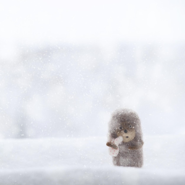 Egel in de mist Kleine speelgoed egel in de sneeuw op besneeuwde achtergrond Kerst Nieuwjaar Winter achtergrond