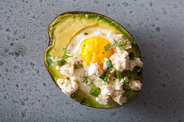 Egg baked in avocado with cheese and herbs