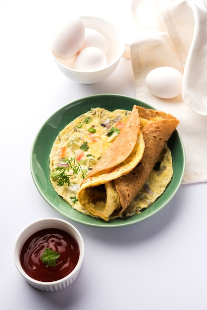 Egg Chapati - 오믈렛 롤 또는 Franky. 인도 어린이용 티핀이나 도시락을 위한 인기 있고 빠르고 건강한 요리법. 변덕스러운 배경 위에 제공됩니다. 선택적 초점