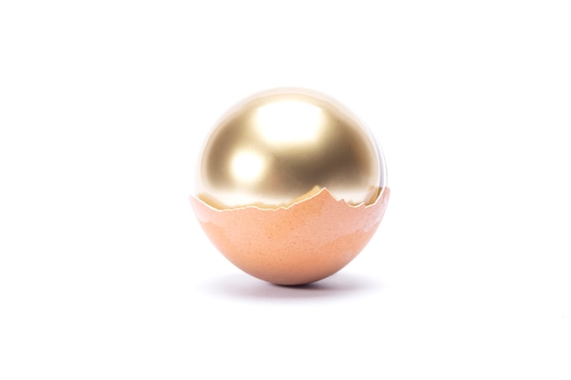 Photo an egg cracked and has golden sphere inside