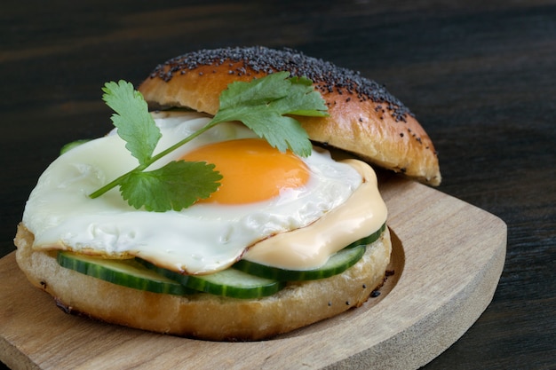 Egg and cucumber sandwich on wooden background.