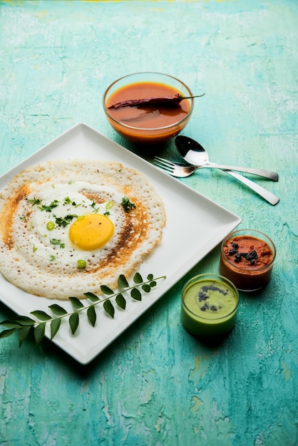 Egg Dosa는 삼바와 처트니와 함께 제공되는 인기 있는 남인도 비채식 아침 식사 또는 식사입니다.