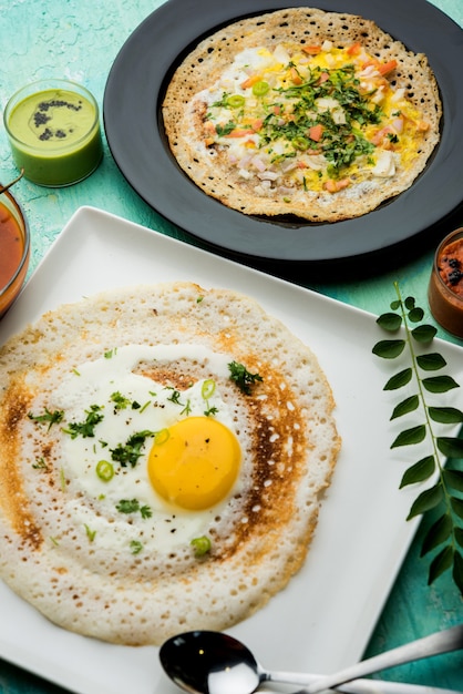 Egg Dosa는 삼바와 처트니와 함께 제공되는 인기 있는 남인도 비채식 아침 식사 또는 식사입니다.