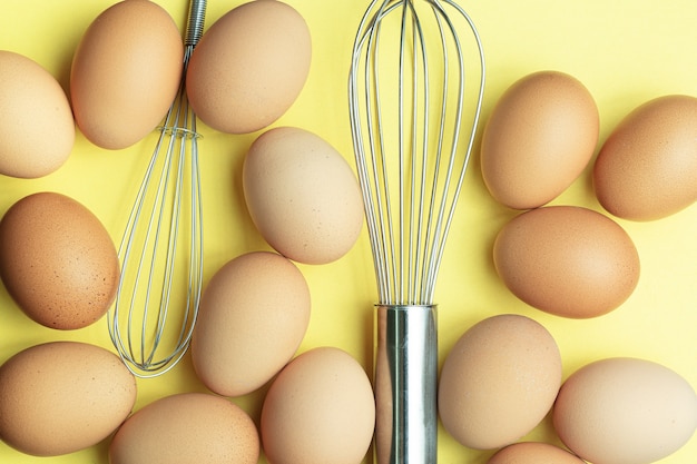 Egg and egg beater on yellow backgroundchicken eggs brown eggs
broken egg in carton box