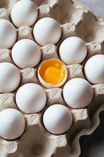 Photo egg in egg tray with one egg cracked