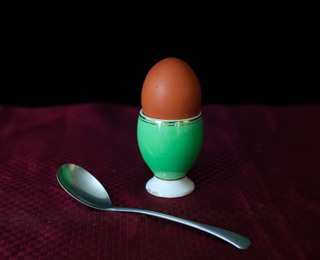 An egg in an eggcup and a silver spoon