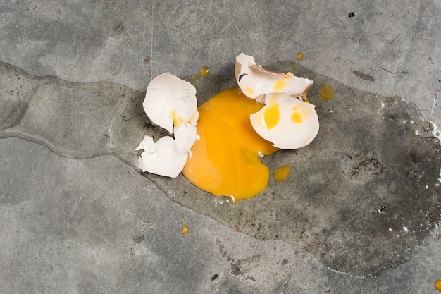 Egg fall and broken on concrete floor 