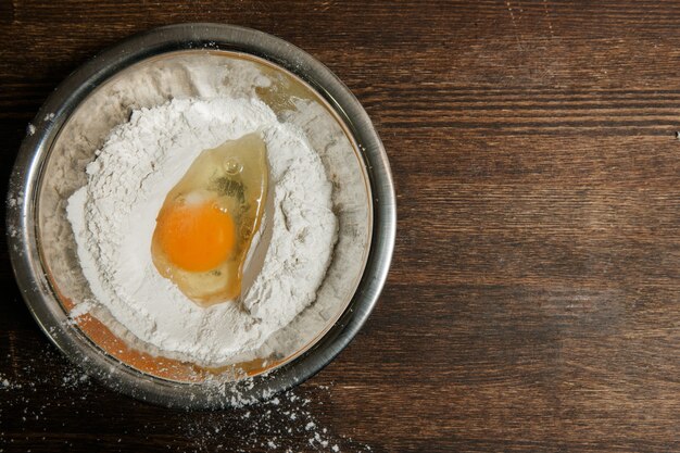 Egg and flour mix in plate on wooden table