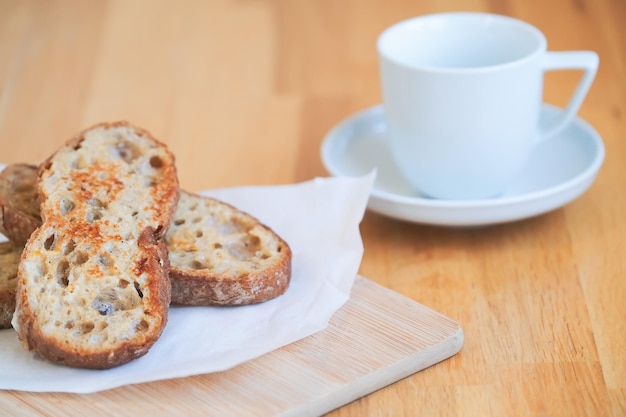 Жареный хлеб с яйцом, итальянская чиабатта на деревянной доске и чашка белого кофе на столе, идея для завтрака