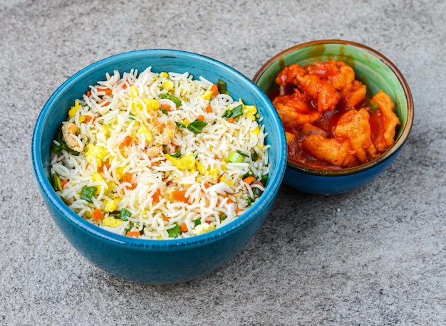 Egg fried rice with sweet and sour chicken served in bowl isolated on background top view of asian food