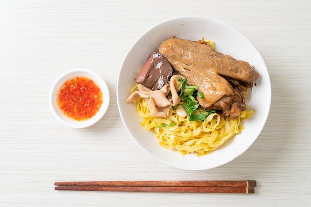 鴨の蒸し煮と一緒に乾麺を提供する卵麺-アジア料理スタイル
