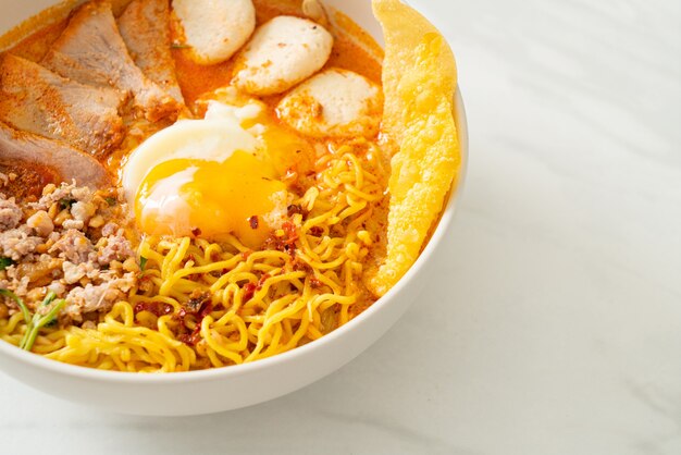 Egg noodles with pork and meatball in spicy soup or tom yum noodles in asian style