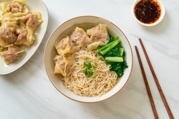 ポークワンタンスープまたはポーク餃子スープと野菜の卵麺-アジア料理スタイル