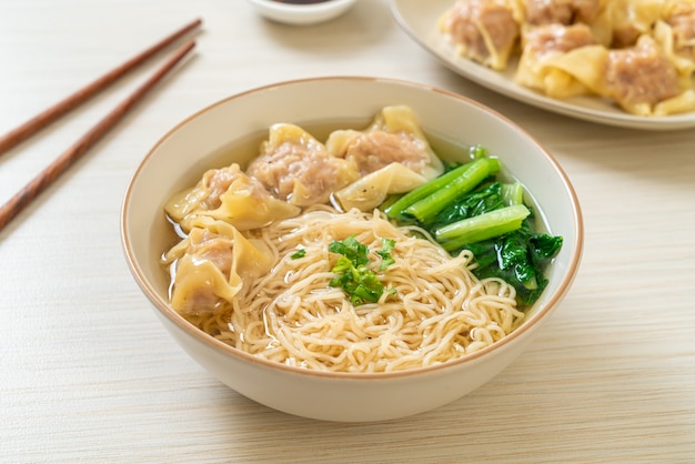 Pasta all'uovo con zuppa di fagottini di maiale o zuppa di gnocchi di maiale e verdure - stile alimentare asiatico