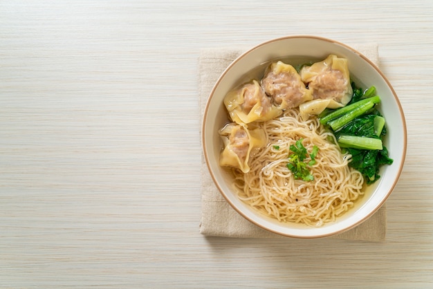 egg noodles with pork wonton soup or pork dumplings soup and vegetable - Asian food style