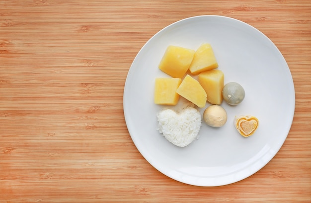 Foto patate e riso all'uovo per purè su tavola di legno.