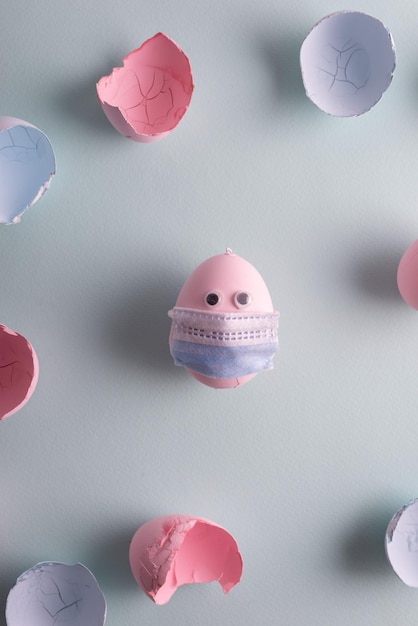 Egg in a protective medical mask Coronavirus Easter in pastel colors Pink blue holiday quarantine concept