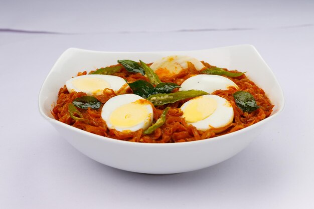 Egg roast or Indian egg masala curry spicy red egg roast arranged in a white ceramic bowl