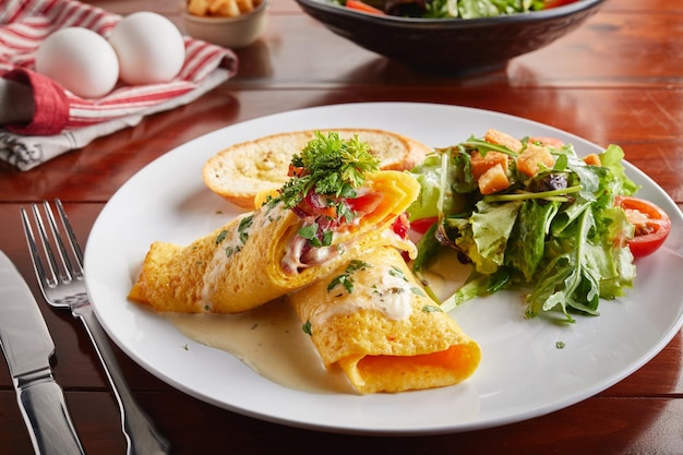 Photo egg rolled with salad served in a dish isolated on wooden background side view