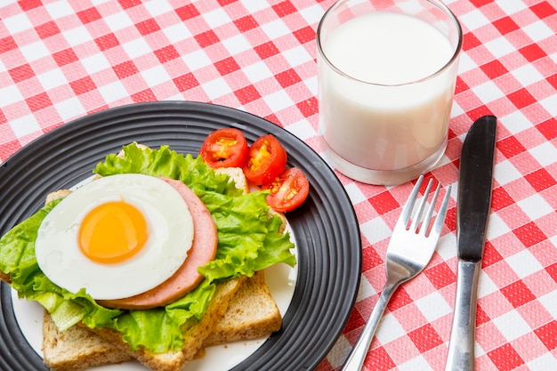 Сэндвич с яйцом и молоком на обеденном столе