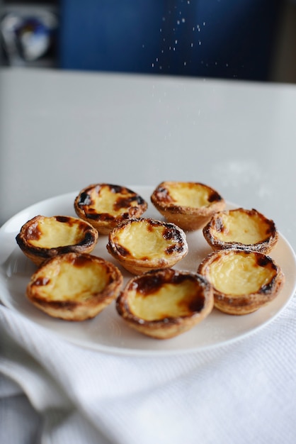 Egg tart traditional Portuguese dessert pastel de nata pasteis on a plate Grey stone background