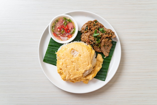 豚肉のグリルとスパイシーソースをトッピングしたご飯に卵