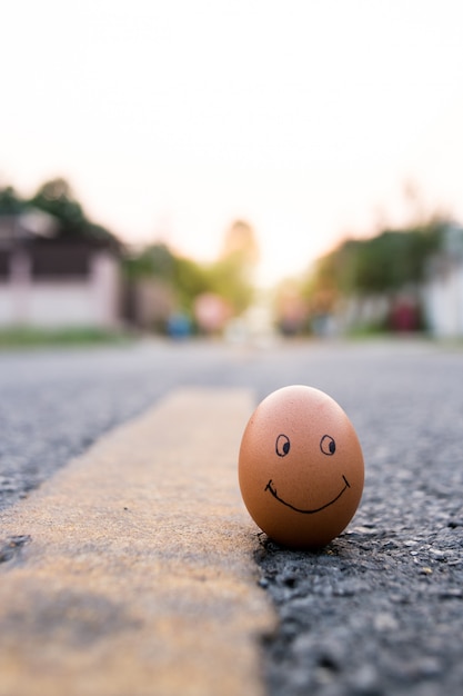 사진 도로에 행복한 사람 근처에 그려진 슬픈 얼굴로 달걀. 우울증의 위협