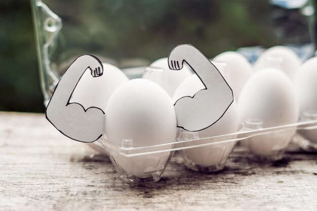 Egg with muscles, concept of egg protein, sports nutrition, diet for muscular building