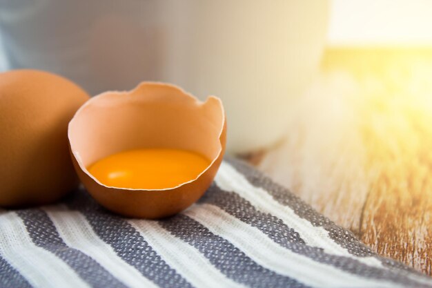 Egg yolk in an eggshell on a wooden background Preparing breakfast