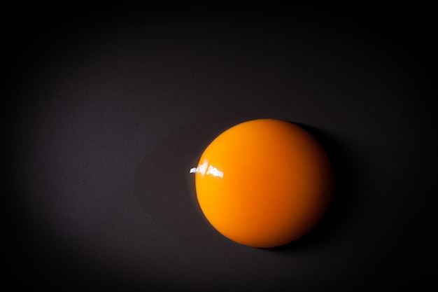 Photo egg yolk isolated on black background with space for copy