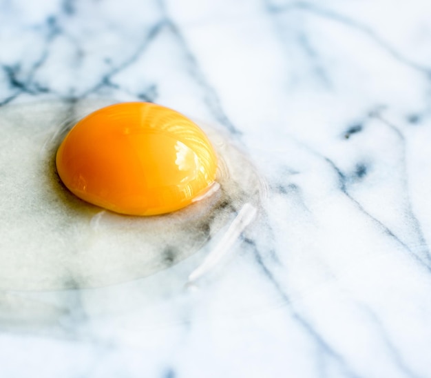 Egg yolk on marble recipe ingredients and homemade cooking concept