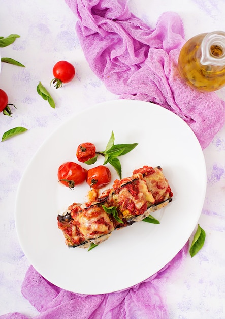 Eggplant (aubergine) rolls with meat in tomato sauce. Flat lay. Top view