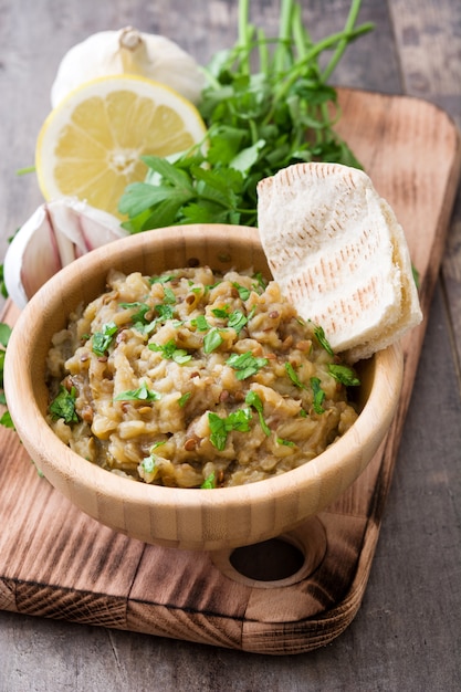 Eggplant baba ganoush and pita bread on wooden