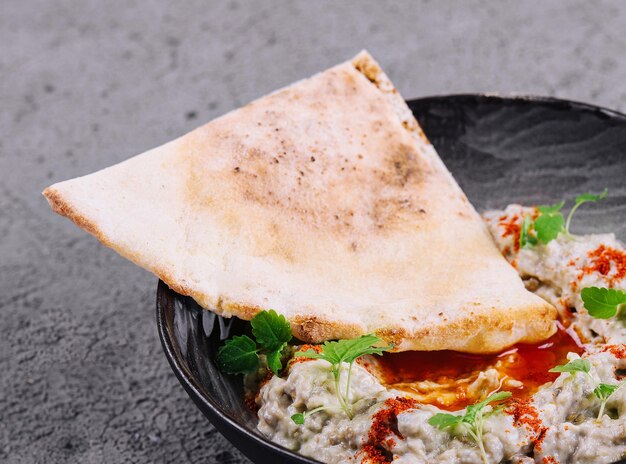 Eggplant caviar with lavash on black bowl