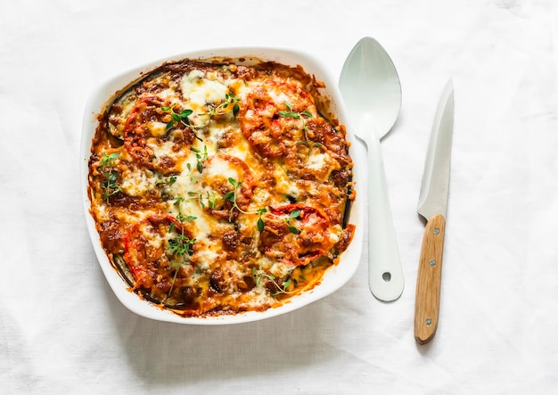 Eggplant chicken tomatoes mozzarella cheese tomato sauce casserole on a light background top view