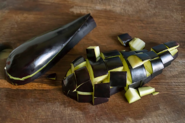 Eggplant cubes on a wooden board Ripe eggplant is diced