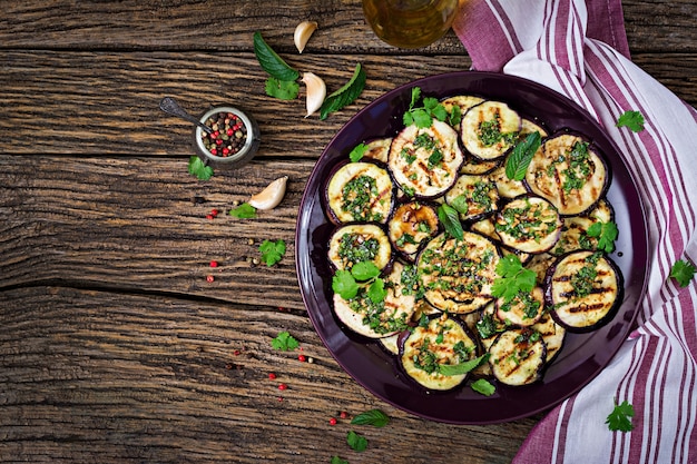 Eggplant grilled with balsamic sauce, garlic, cilantro and mint. Vegan food. Grilled aubergine. Top view. Flat lay