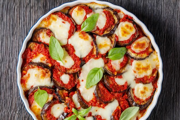 Eggplant parmigiana aubergine baked in a dish with tomato sauce\
basil parmesan and mozzarella cheese italian cuisine flat lay\
closeup