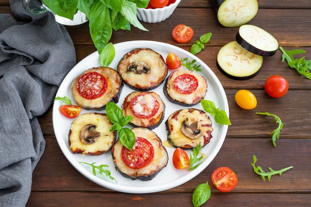 Eggplant pizza with tomatoes sauce mozzarella mushrooms and fresh basil Selective focus