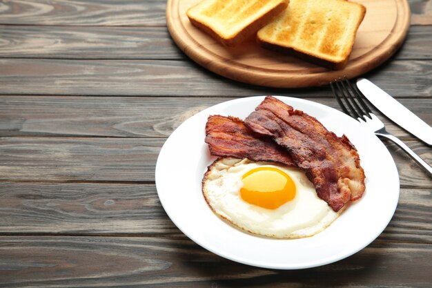 Eggs and bacon for breakfast on brown surface